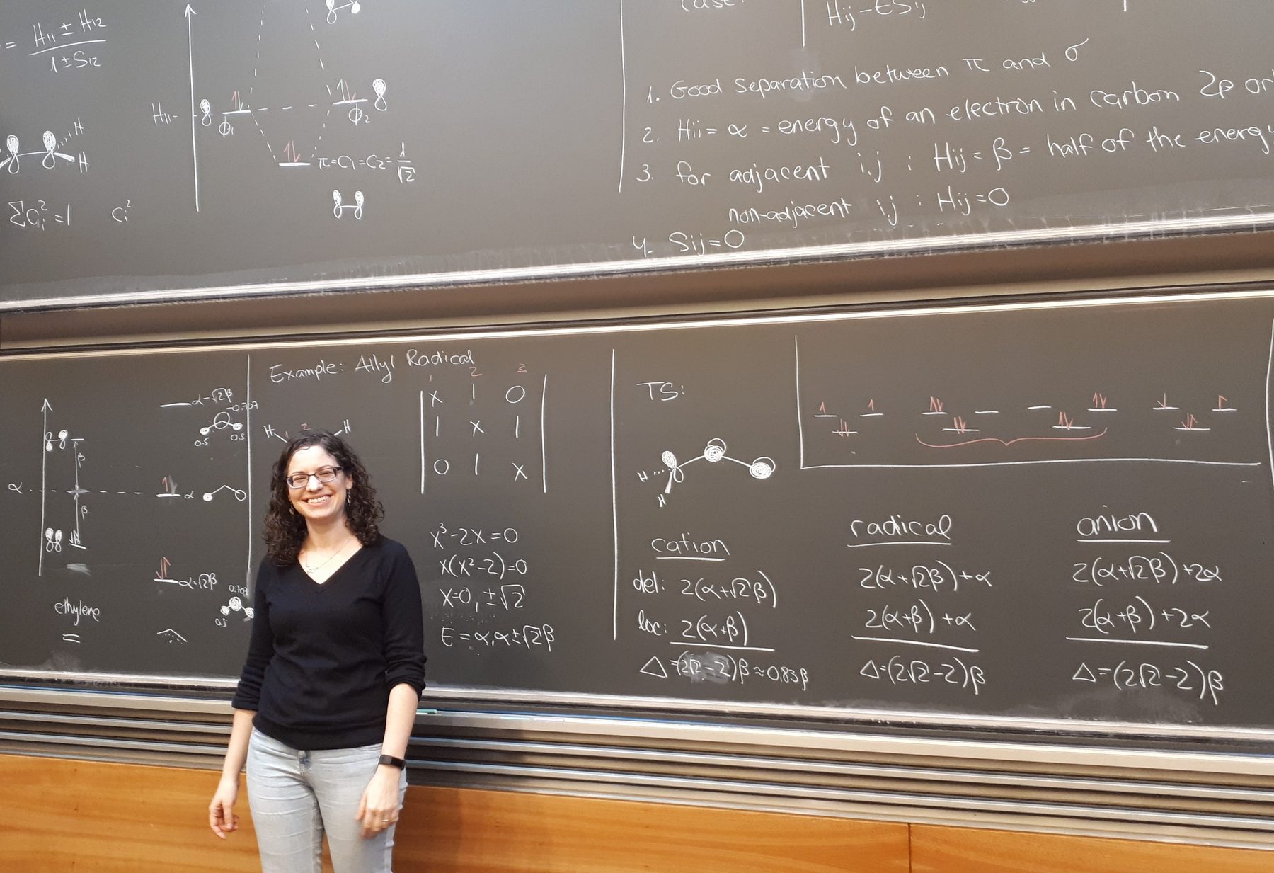 Renana teaching molecular orbital theory in front of a full blackboard